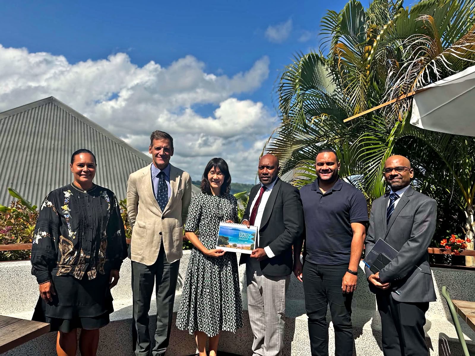 IFC Division Director for East Asia and the Pacific, Ms. Keiko Miwa, hands the Espiritu Santo Investor Information Document 2026 to Director General Mr. Noah Patrick Kouback, witnessed by Director of Tourism Mr. Paul Pio. Mangoes Restaurant, Port Vila, 17 September 2026.